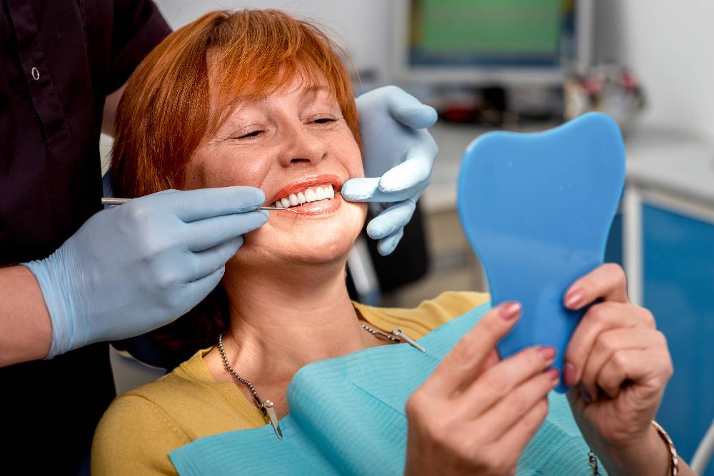 A woman in Birmingham, AL admiring her newly acquired dental implants