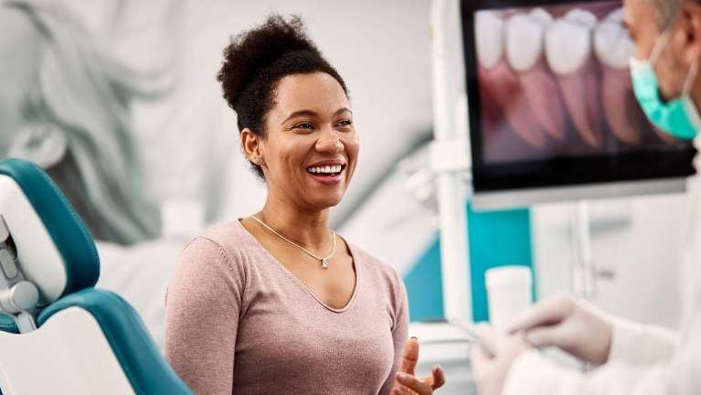 Lady chatting with the dentist before getting dental implants in Birmingham, AL