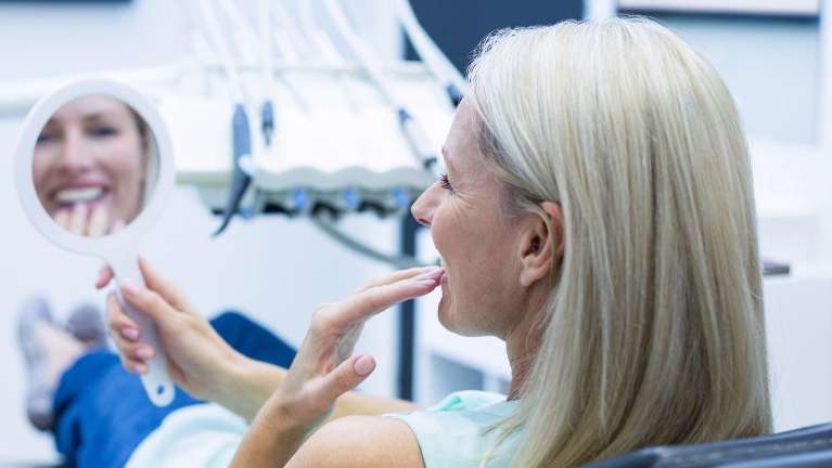 A female patient admiring her Porcelain Veneers in Birmingham, AL