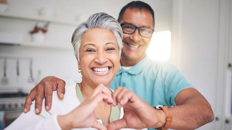 a Couple smiling after replacing a missing tooth in Birmingham 