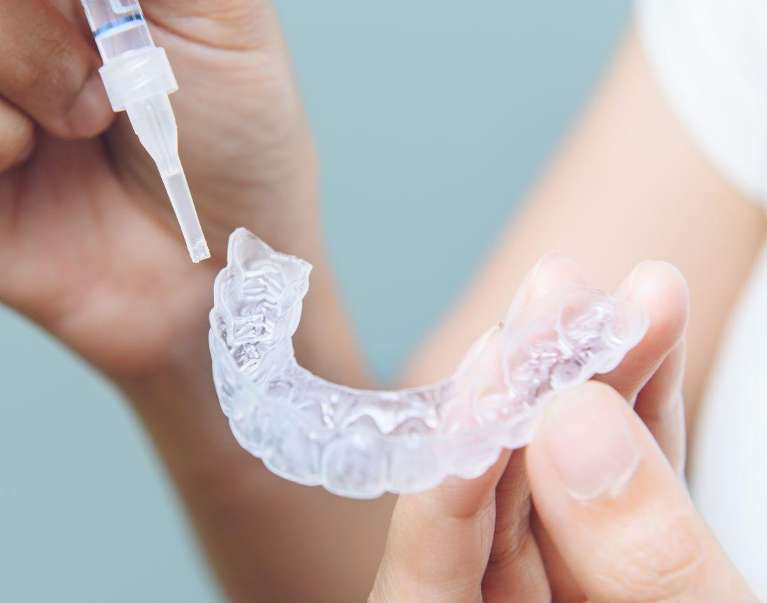 A person disinfecting an Invisalign in Birmingham, AL