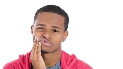 Man holding his jaw due to tooth pains in Birmingham, AL